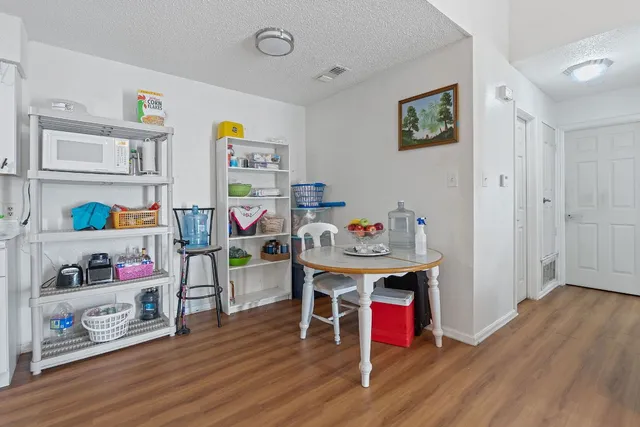a utility room with stainless steel appliances furniture and wooden floor