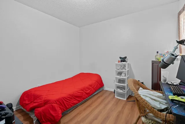 a blue bed sitting in a bedroom next to a desk and chair