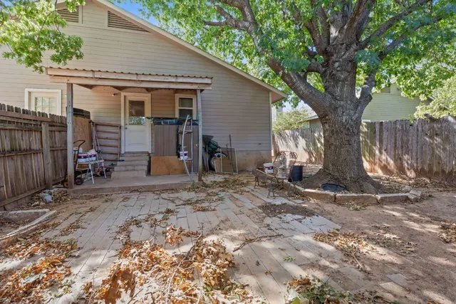 a view of a house with backyard and a tree