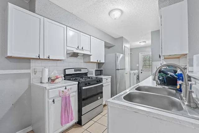 a kitchen that has a sink cabinets counter space and appliances