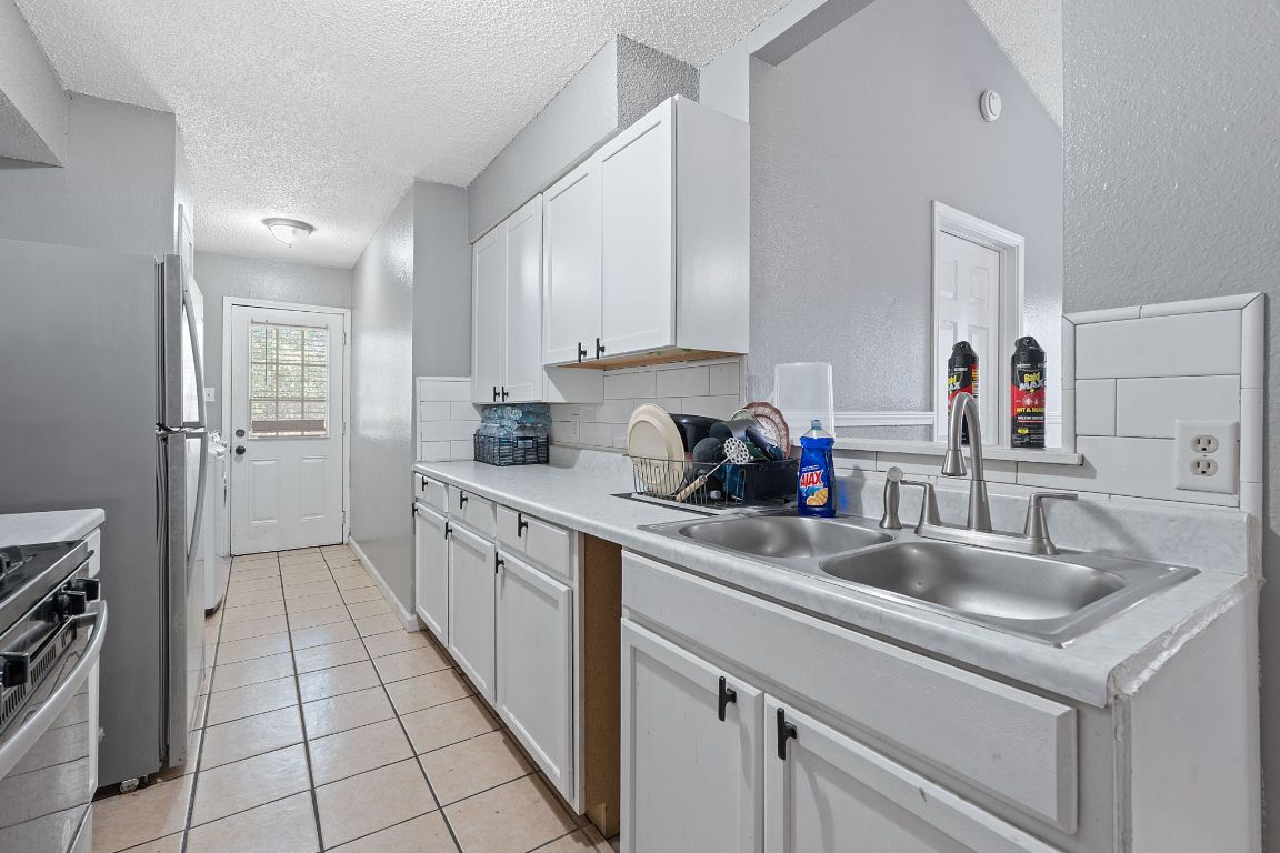 1105 Quail Valley Drive Georgetown, TX 78626 - Photo 27 of 38 a kitchen that has a sink cabinets counter space and appliances