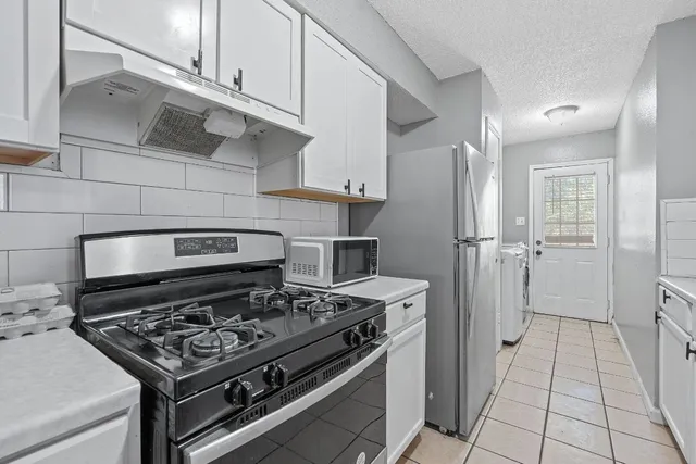 a kitchen with granite countertop a sink a stove and cabinets