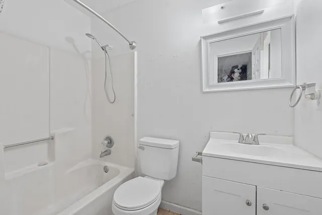 a backyard of a house with large trees and wooden fence