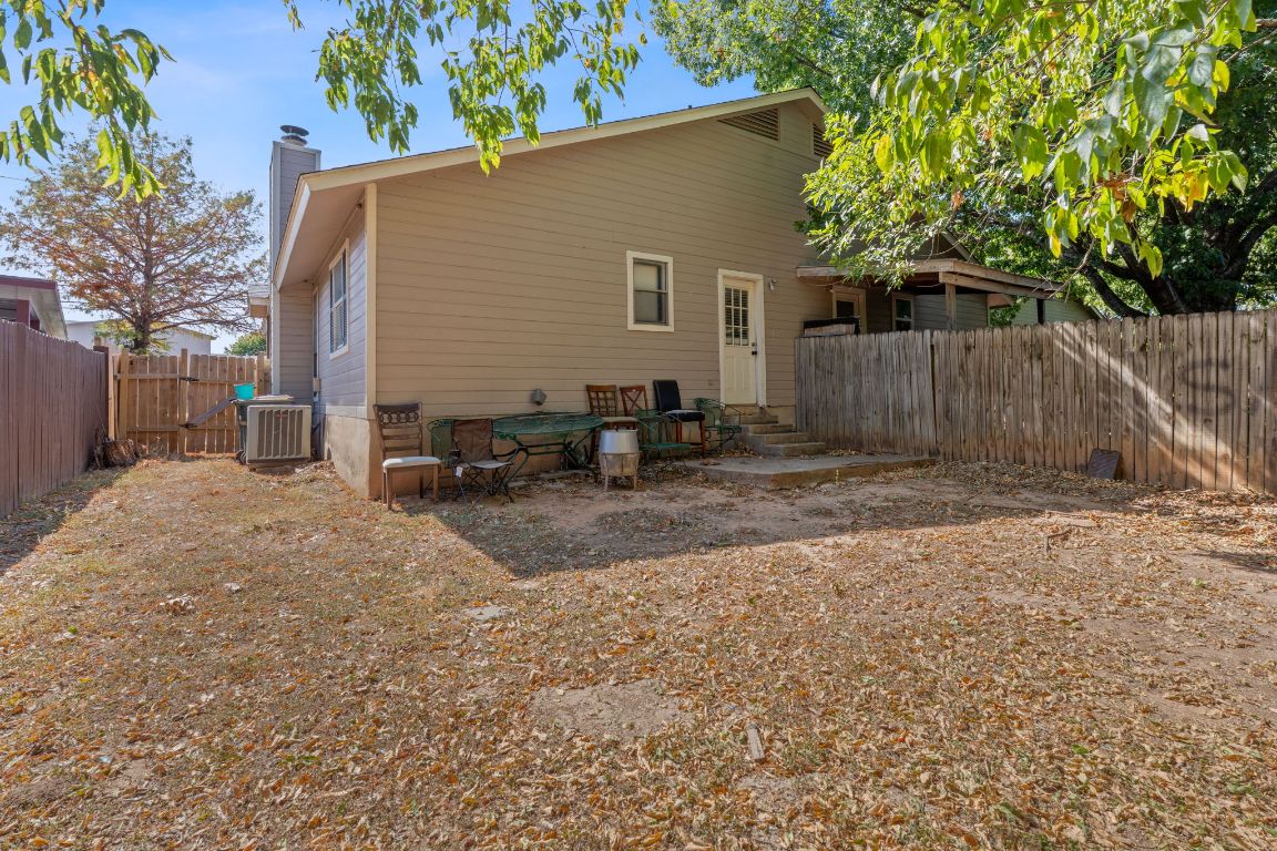 1105 Quail Valley Drive Georgetown, TX 78626 - Photo 38 of 38 a backyard of a house with chairs and a tree