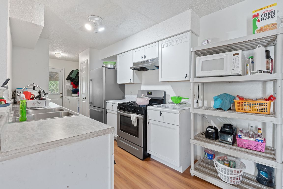 1105 Quail Valley Drive Georgetown, TX 78626 - Photo 5 of 38 a kitchen with granite countertop lots of clutter and stainless steel appliances
