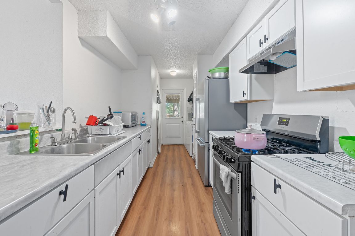 1105 Quail Valley Drive Georgetown, TX 78626 - Photo 6 of 38 a kitchen with a stove and a white cabinets