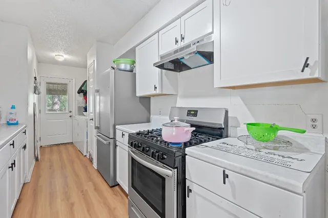 a kitchen with stainless steel appliances granite countertop a lot of cabinets a stove and a refrigerator