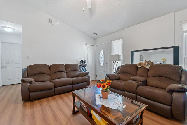 a living room with furniture and a wooden floor