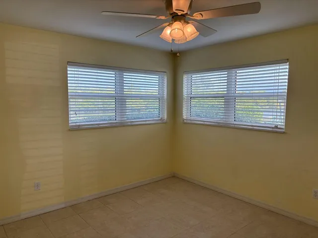 an empty room with a chandelier fan and closet