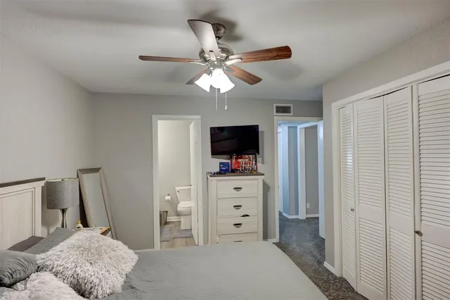 a bedroom with a bed and a flat tv screen on dresser