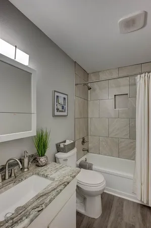 a bathroom with a granite countertop sink toilet and shower