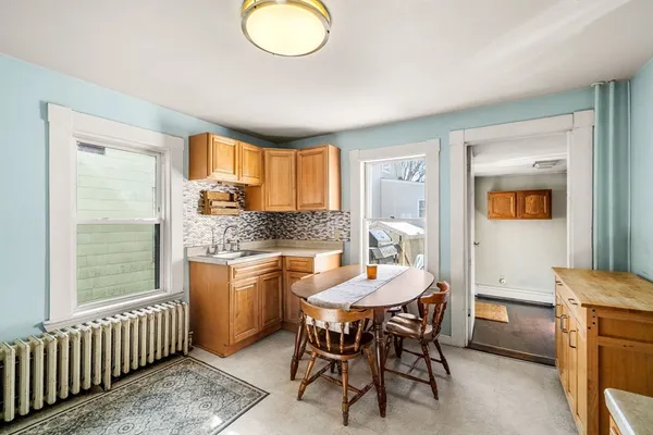 a kitchen with a dining table chairs and large window
