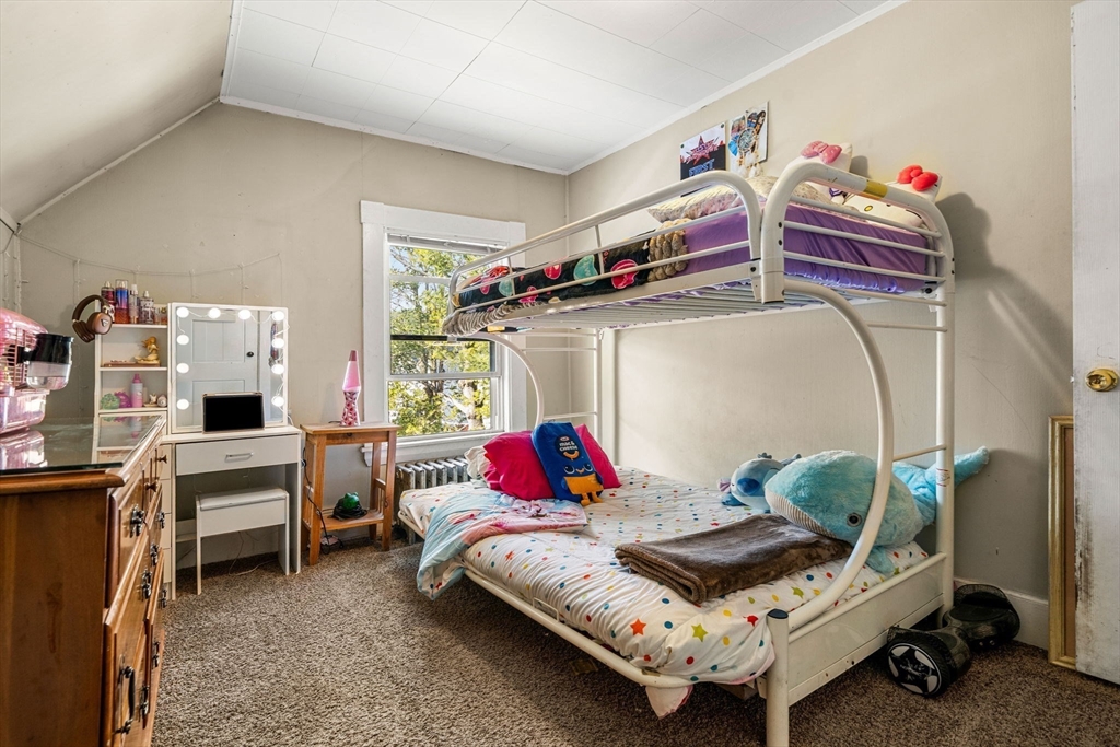 12 Arthur Street Gloucester, MA 01930 - Photo 24 of 33 a bedroom with a bed and a chandelier