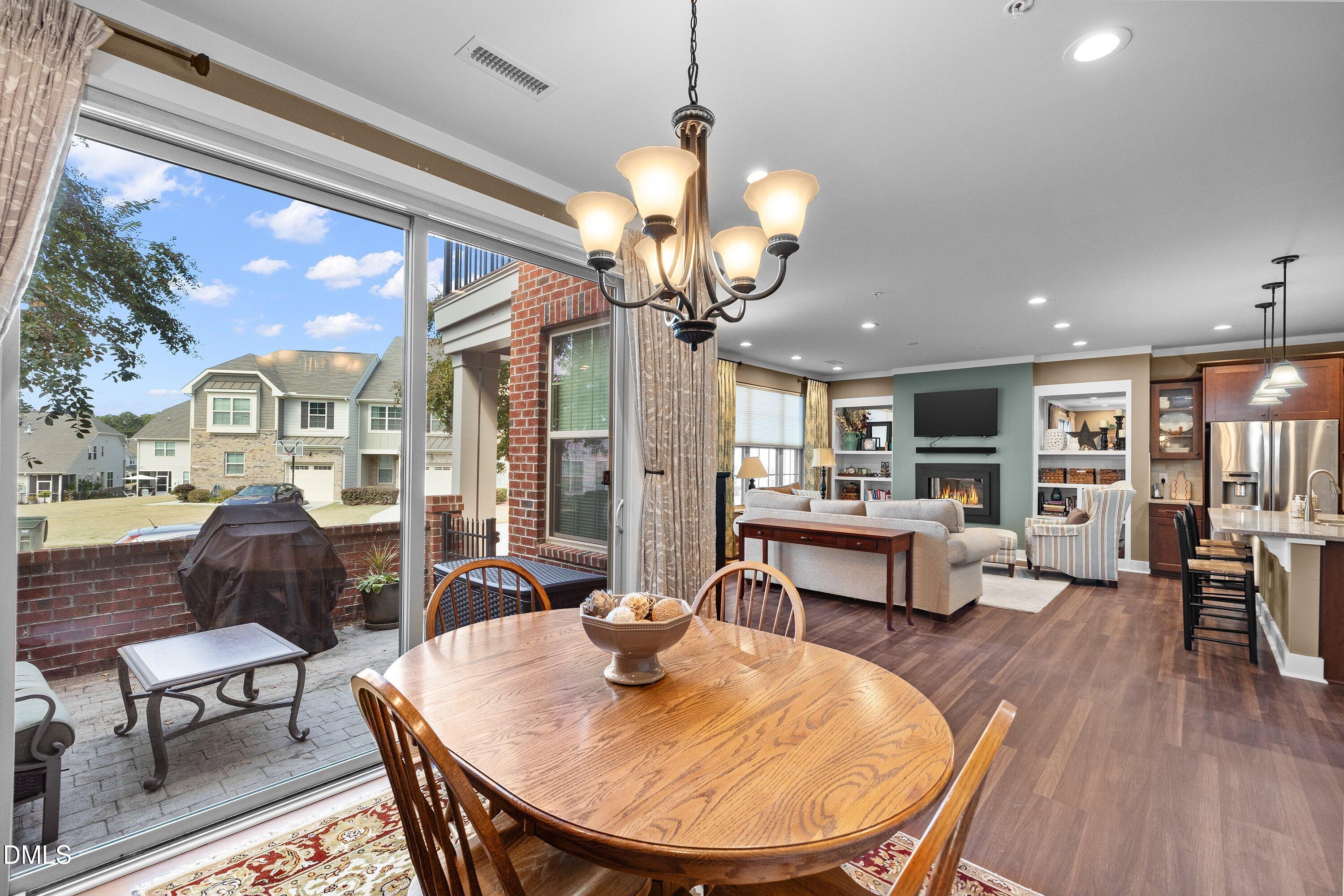 9302 Alcazar Walk Raleigh, NC 27617 - Photo 11 of 40 a living room with dining table and a chandelier