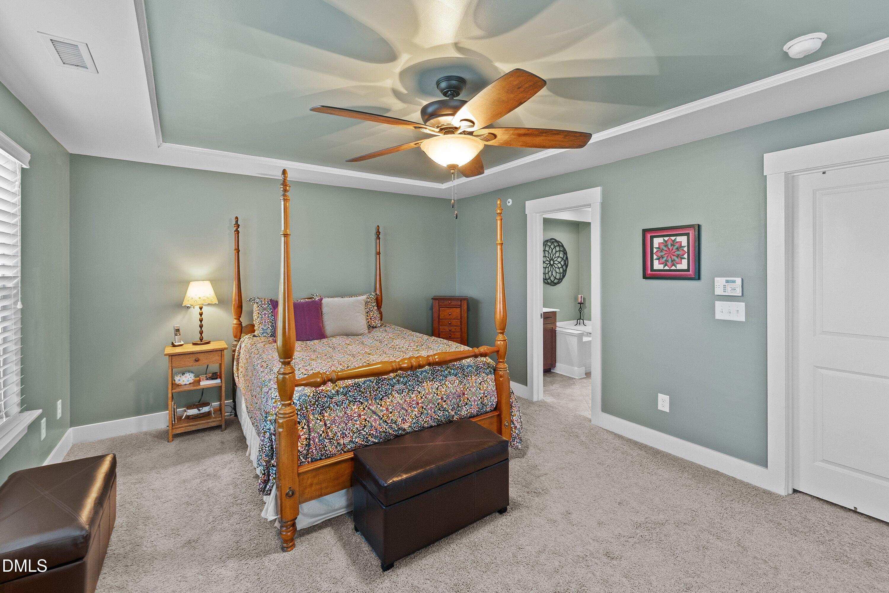 9302 Alcazar Walk Raleigh, NC 27617 - Photo 17 of 40 a bedroom with a bed and a chandelier