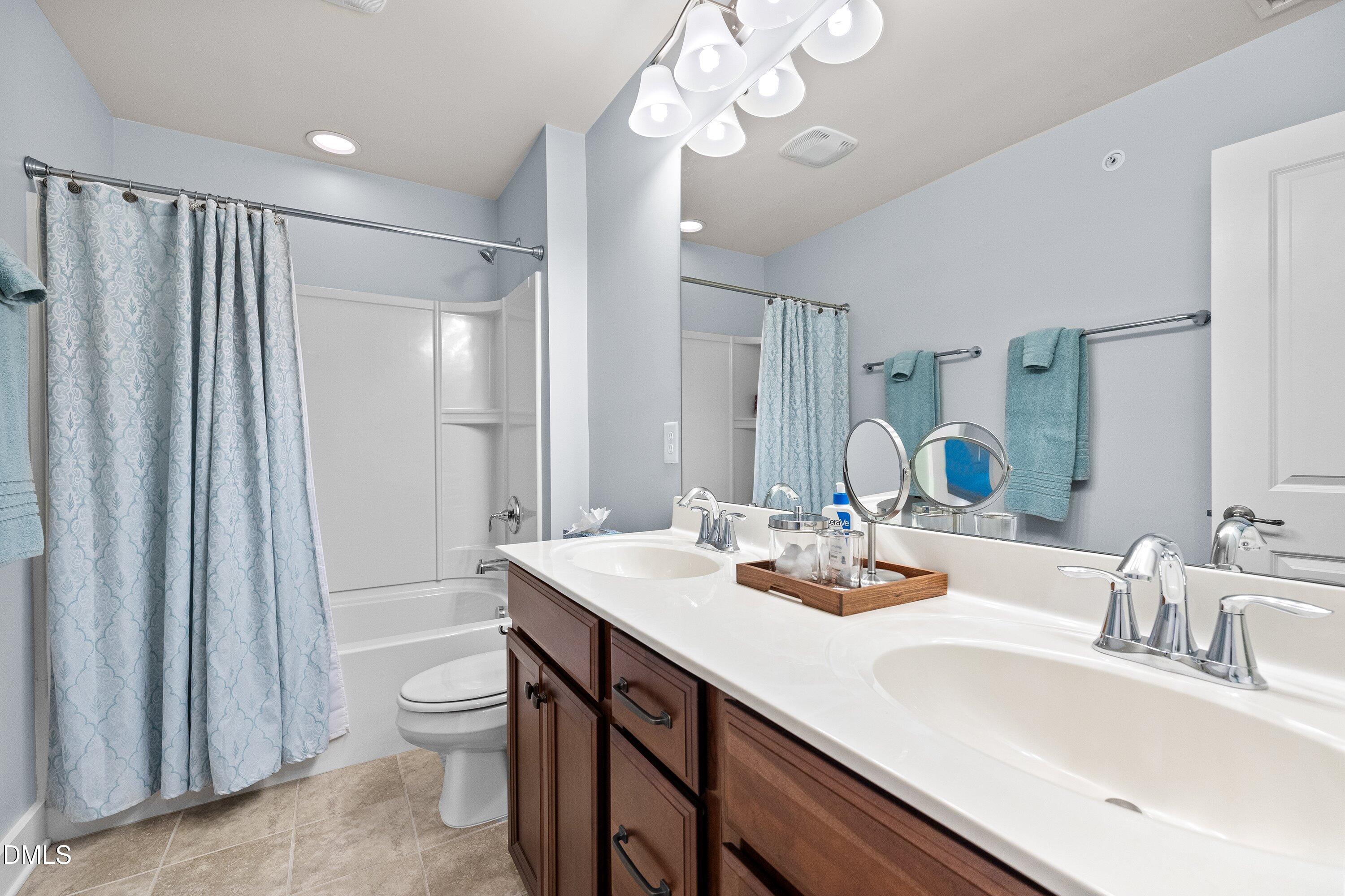 9302 Alcazar Walk Raleigh, NC 27617 - Photo 23 of 40 a bathroom with a sink a toilet and a large mirror