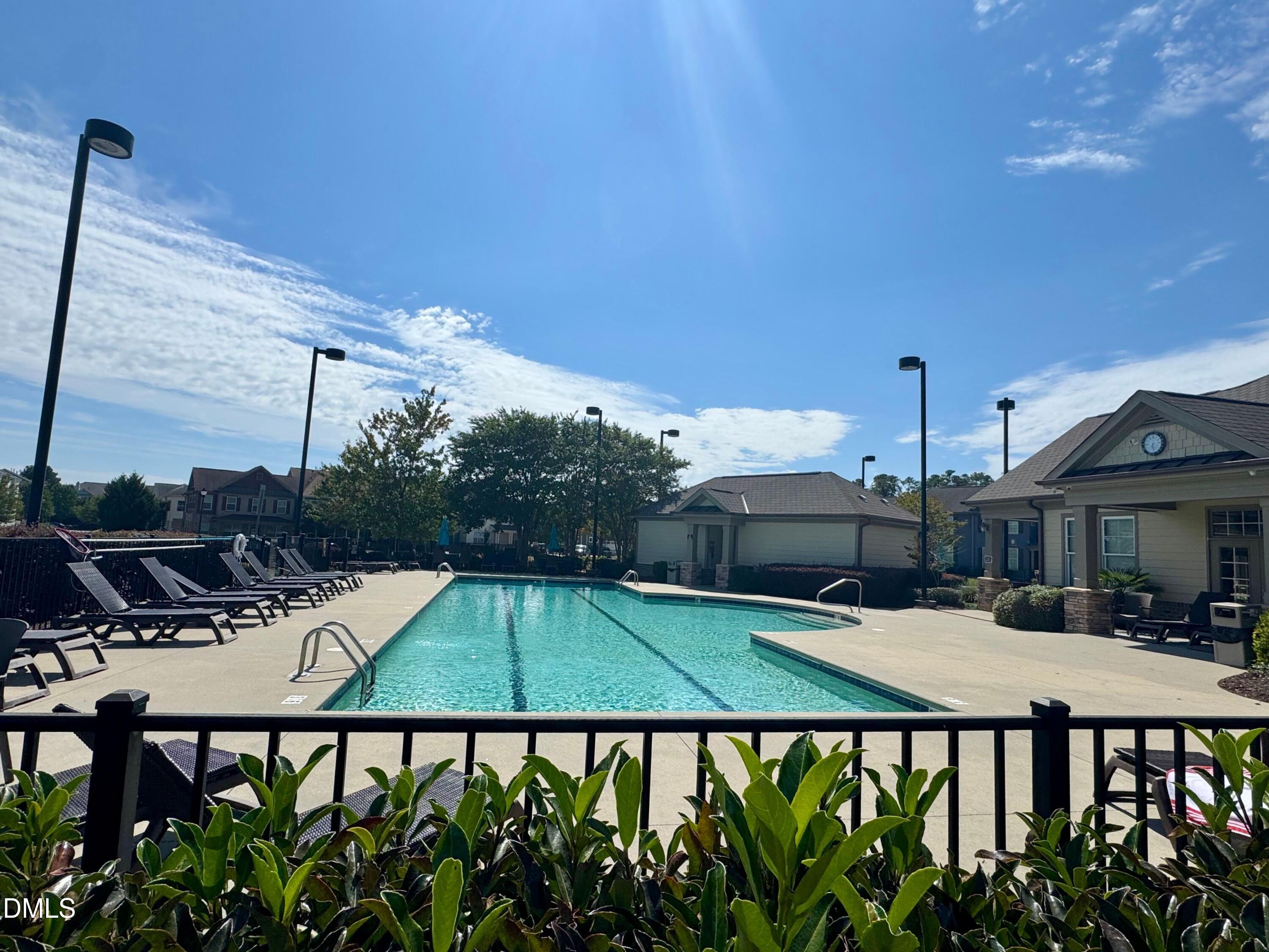 9302 Alcazar Walk Raleigh, NC 27617 - Photo 34 of 40 a view of a patio with a table and chairs under an umbrella with wooden fence