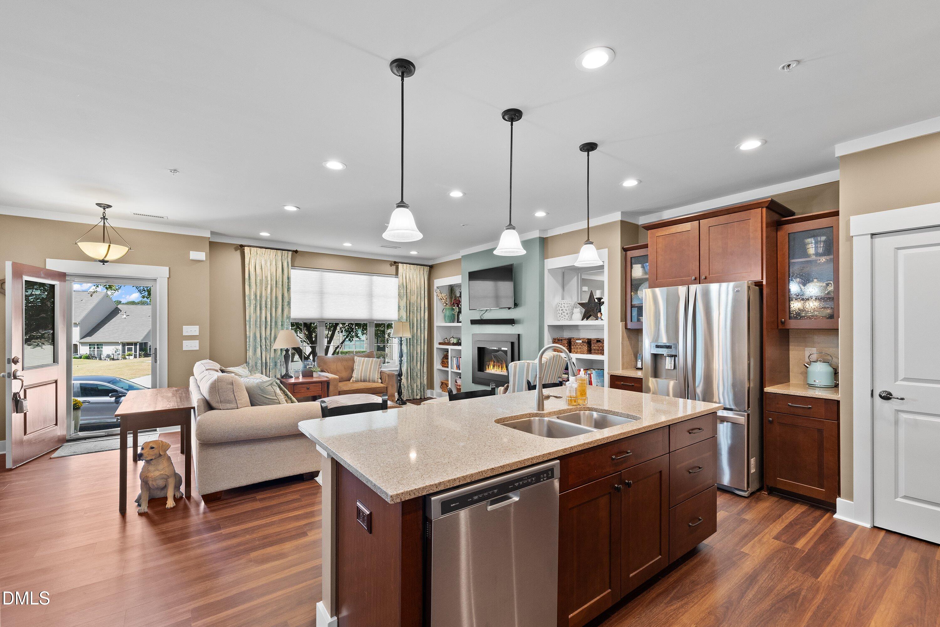 9302 Alcazar Walk Raleigh, NC 27617 - Photo 6 of 40 a open kitchen with stainless steel appliances granite countertop a refrigerator a sink dishwasher a couches with wooden floor and dining table