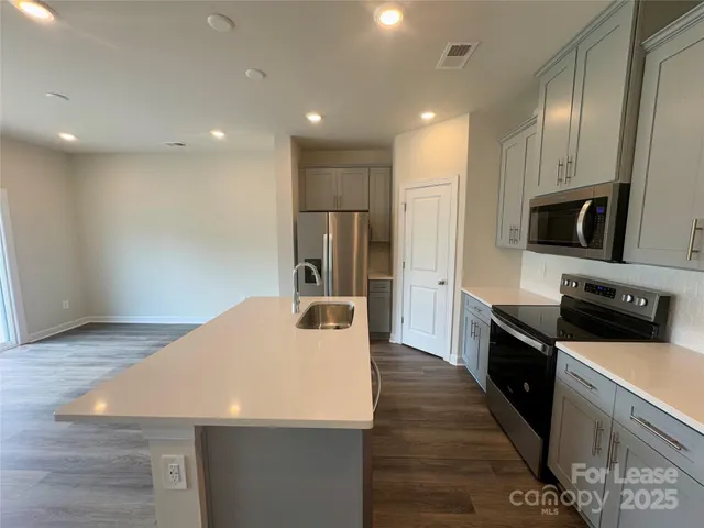 a kitchen with stainless steel appliances a refrigerator sink and microwave