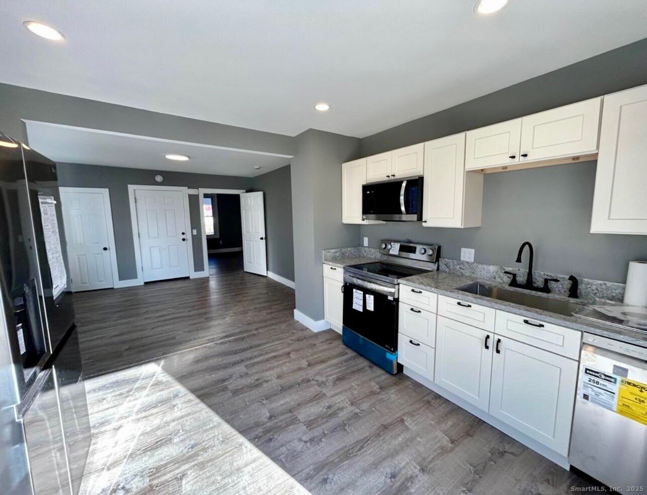 49 Trumbull Avenue Stonington, CT 06378 - Photo 2 of 14 a kitchen with granite countertop a stove top oven a sink a counter space and cabinets
