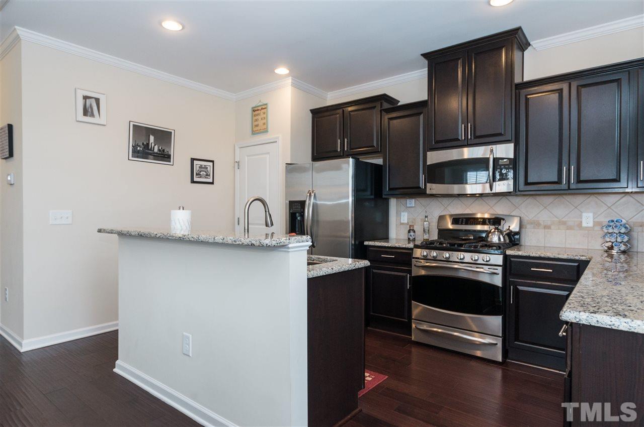 1345 Rodessa Run Raleigh, NC 27607 - Photo 11 of 24 a kitchen with stainless steel appliances granite countertop a refrigerator stove and sink