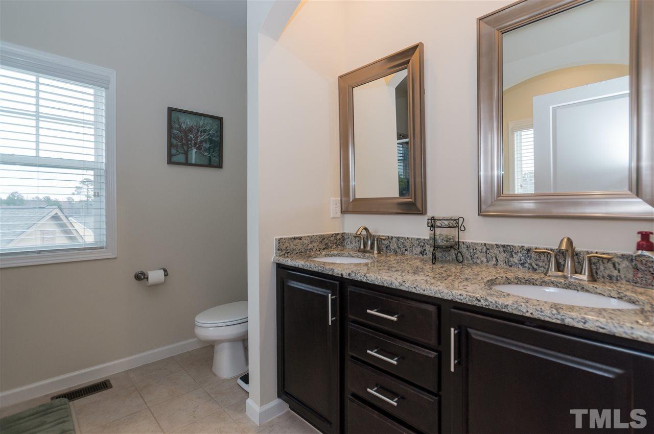 1345 Rodessa Run Raleigh, NC 27607 - Photo 18 of 24 a bathroom with a granite countertop sink a toilet and mirror