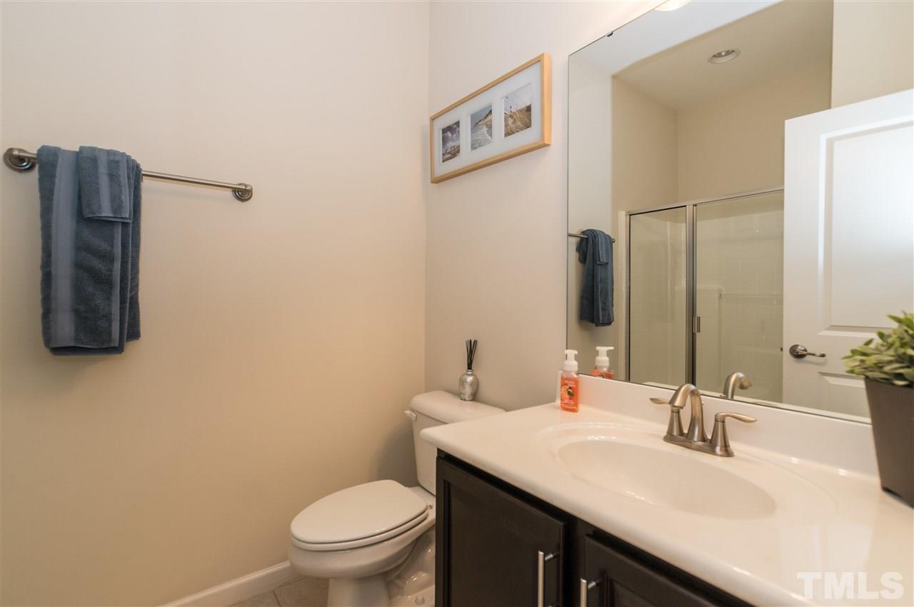 1345 Rodessa Run Raleigh, NC 27607 - Photo 5 of 24 a bathroom with a granite countertop sink a toilet and a mirror