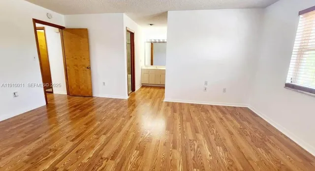 an empty room with wooden floor and a window