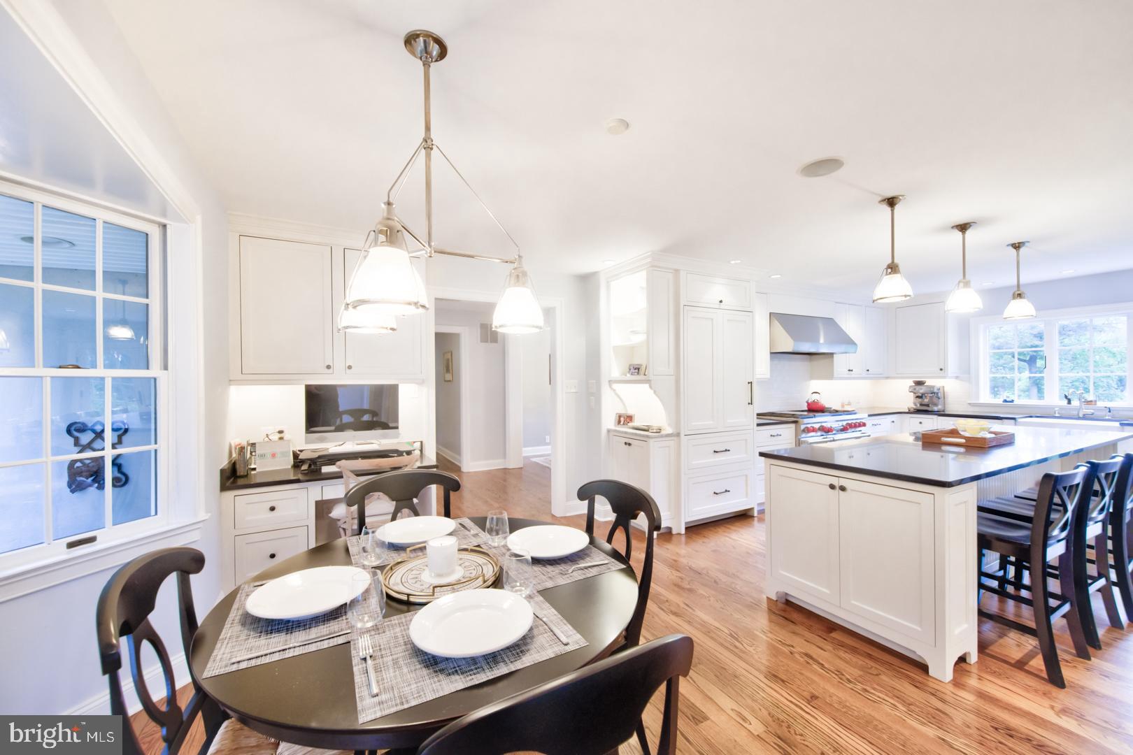 228 South Fairfield Road Devon, PA 19333 - Photo 21 of 61 a open kitchen with stainless steel appliances kitchen island granite countertop a stove a sink a dining table and chairs with wooden floor