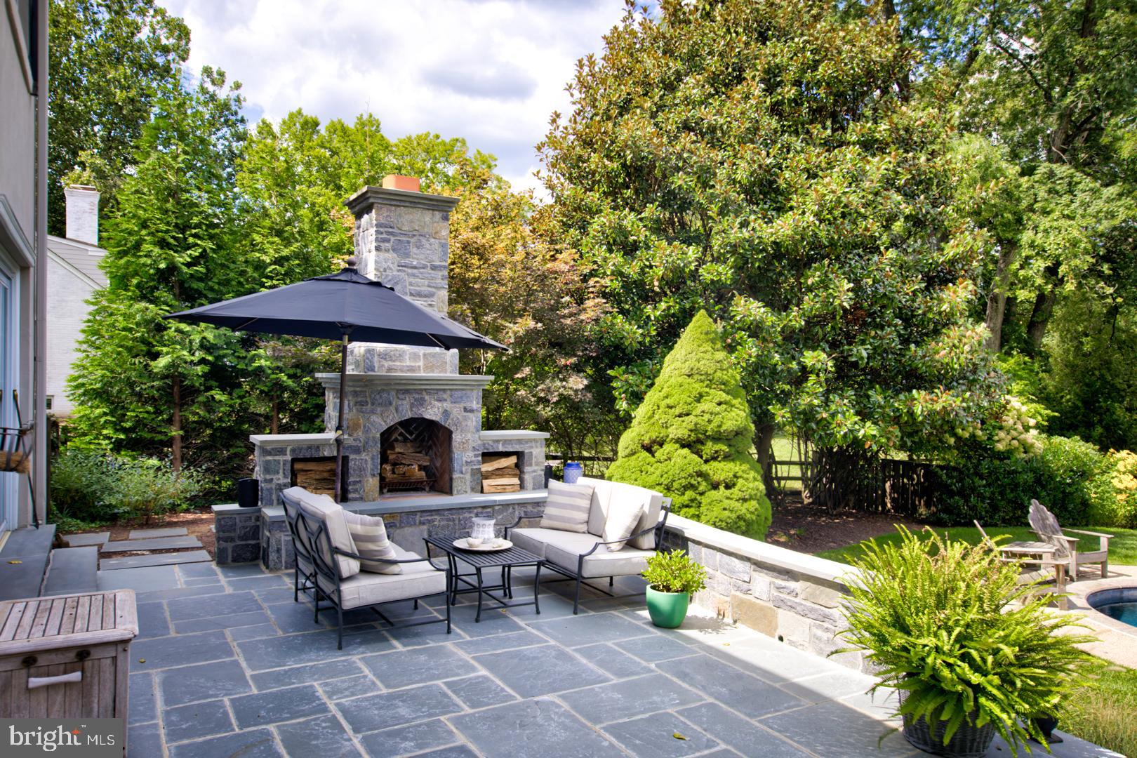 228 South Fairfield Road Devon, PA 19333 - Photo 6 of 61 a view of a patio with couches table and chairs under an umbrella with a fire pit