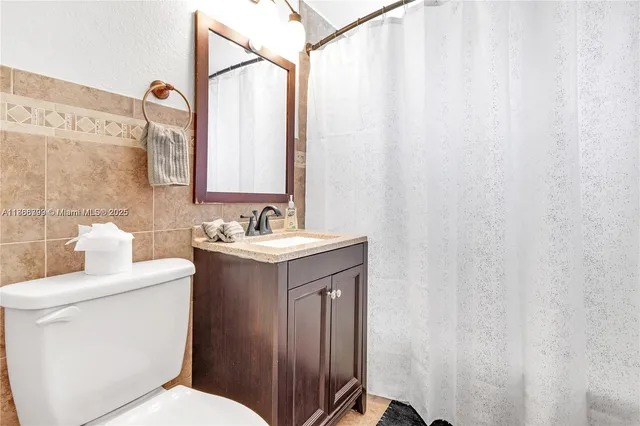 a bathroom with a sink a toilet and shower curtain