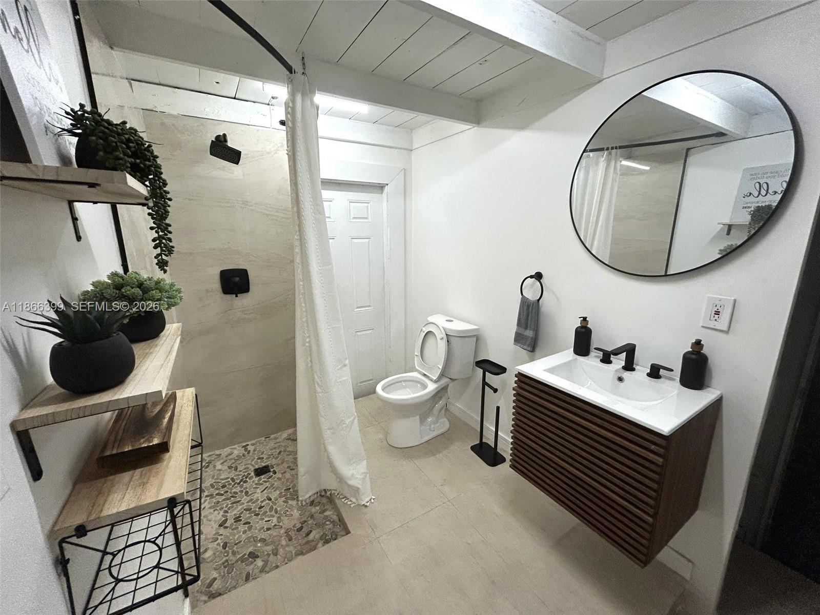 460 Northwest 88th Terrace El Portal, FL 33150 - Photo 17 of 20 a bathroom with a toilet sink and mirror
