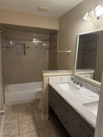 a bathroom with a granite countertop sink a toilet and bathtub
