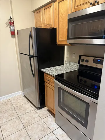 a kitchen with granite countertop a refrigerator and a stove
