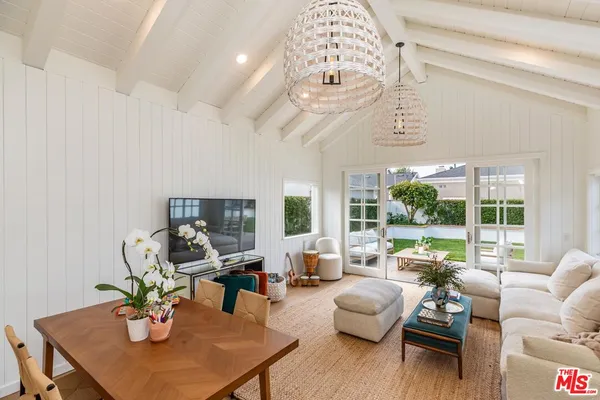 a living room with furniture chandelier and a large window
