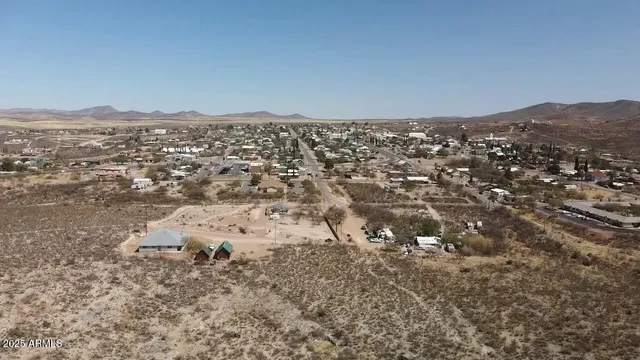 an aerial view of house with yard and mountain view in back