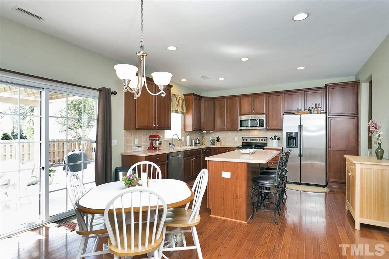 5136 Holly Ridge Farm Road Raleigh, NC 27616 - Photo 13 of 25 a kitchen with stainless steel appliances granite countertop a stove a refrigerator a kitchen island a dining table and chairs