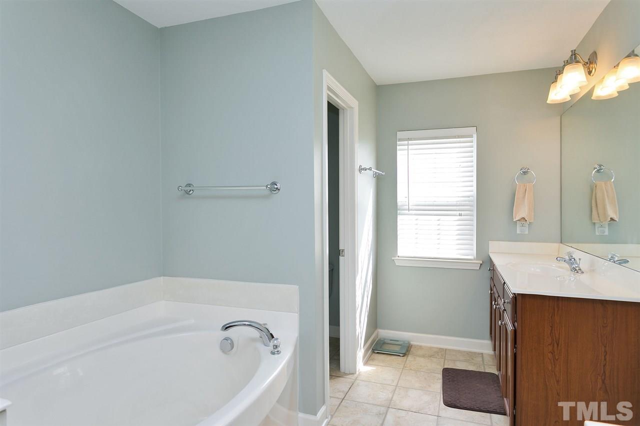 5136 Holly Ridge Farm Road Raleigh, NC 27616 - Photo 19 of 25 a bathroom with a tub sink and a mirror