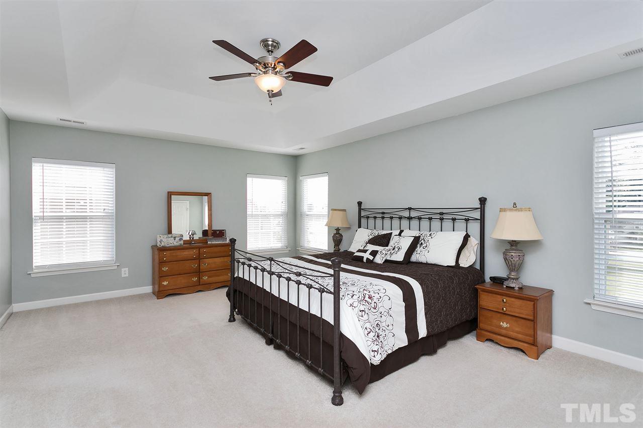 5136 Holly Ridge Farm Road Raleigh, NC 27616 - Photo 3 of 25 a bed room with a bed and a chandelier