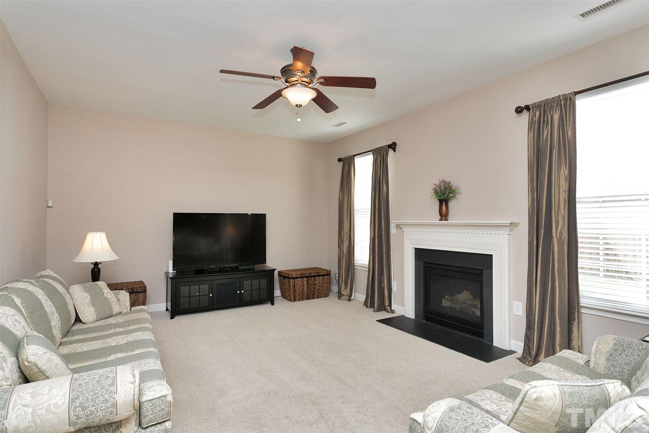 5136 Holly Ridge Farm Road Raleigh, NC 27616 - Photo 10 of 25 a living room with furniture a fireplace and a flat screen tv