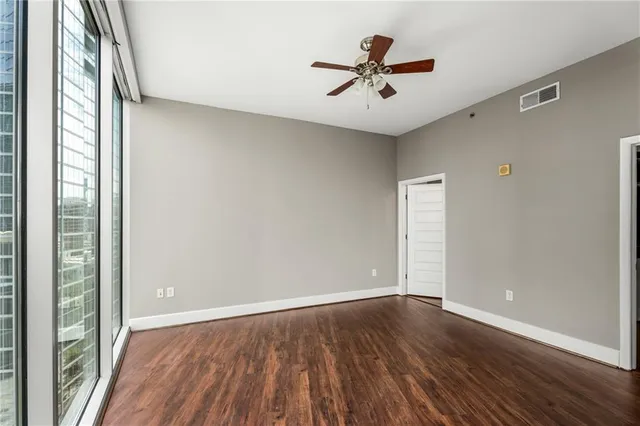 a view of room with hardwood floor and a ceiling fan