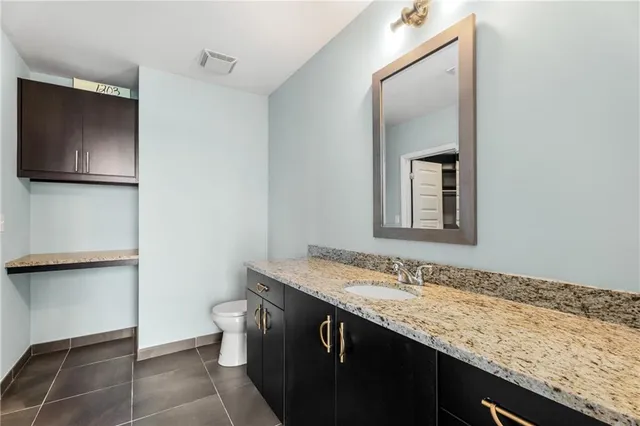 a bathroom with a granite countertop sink and a mirror