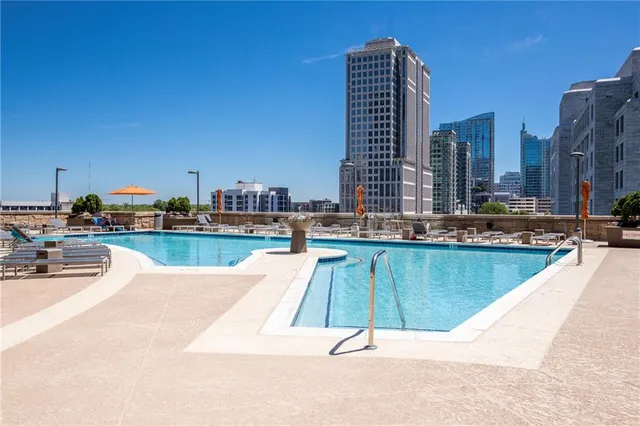 a swimming pool with outdoor seating and city view