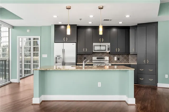 a view of a kitchen with kitchen island a island wooden floor and a counter top space