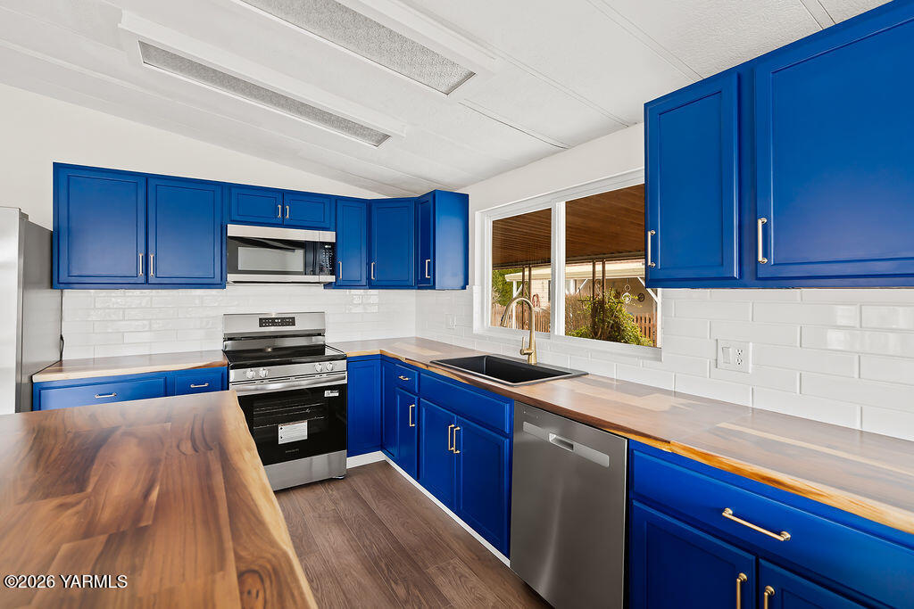 a kitchen with stainless steel appliances granite countertop wooden cabinets a stove top oven a sink and dishwasher