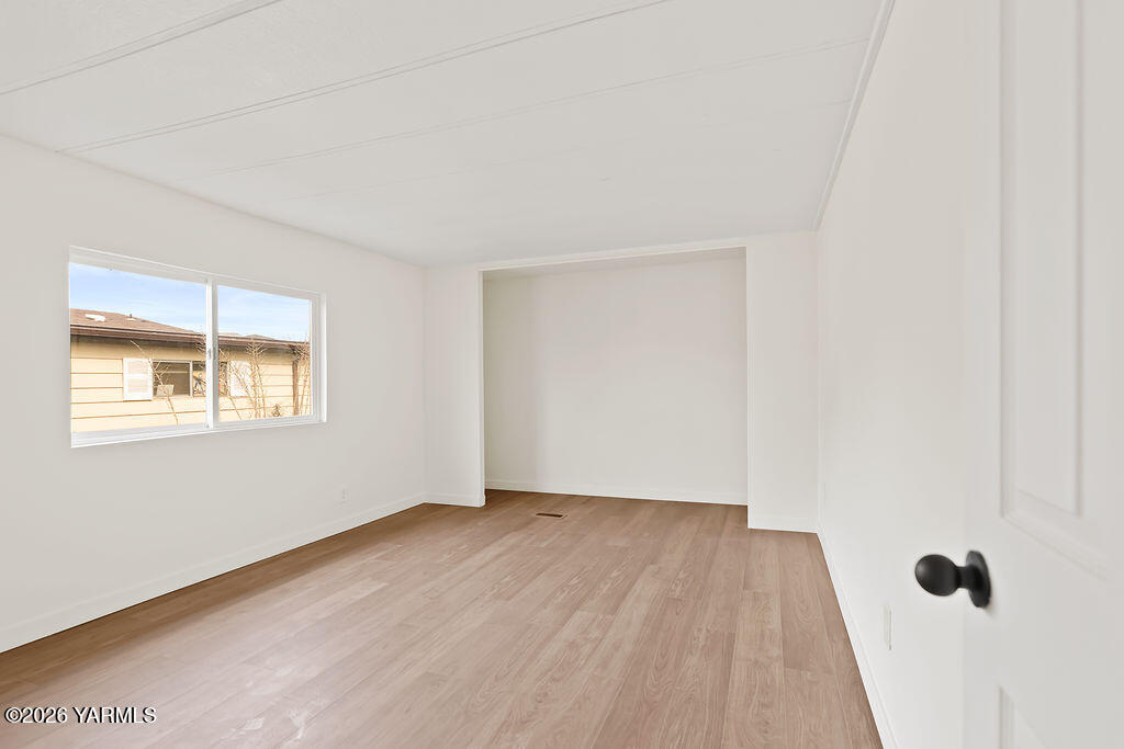 3701 Gun Club Road, Unit 45 Yakima, WA 98901 - Photo 12 of 20 an empty room with wooden floor and windows
