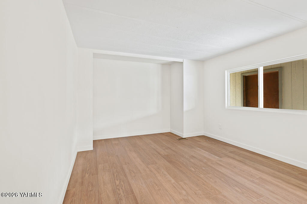 3701 Gun Club Road, Unit 45 Yakima, WA 98901 - Photo 14 of 20 a view of an empty room with wooden floor and a window