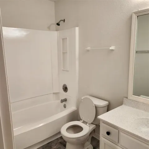 a white toilet sitting next to a bath tub