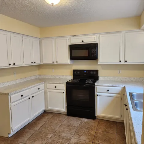 a kitchen with a sink and a stove top oven