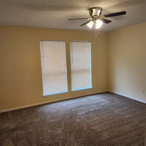 a view of room with ceiling fan and window